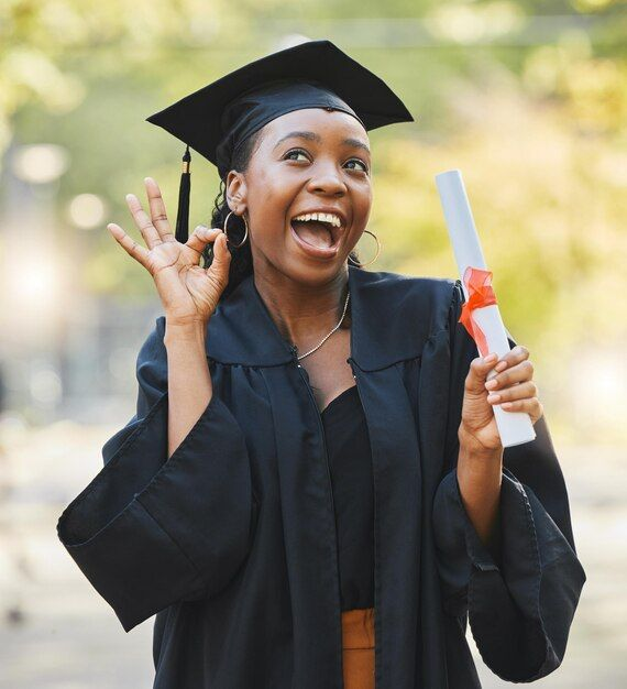 Excited graduate in cap and gown holding a diploma